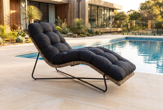 PASSERO Sun Lounger beside a pool on a light porcelain paved terrace