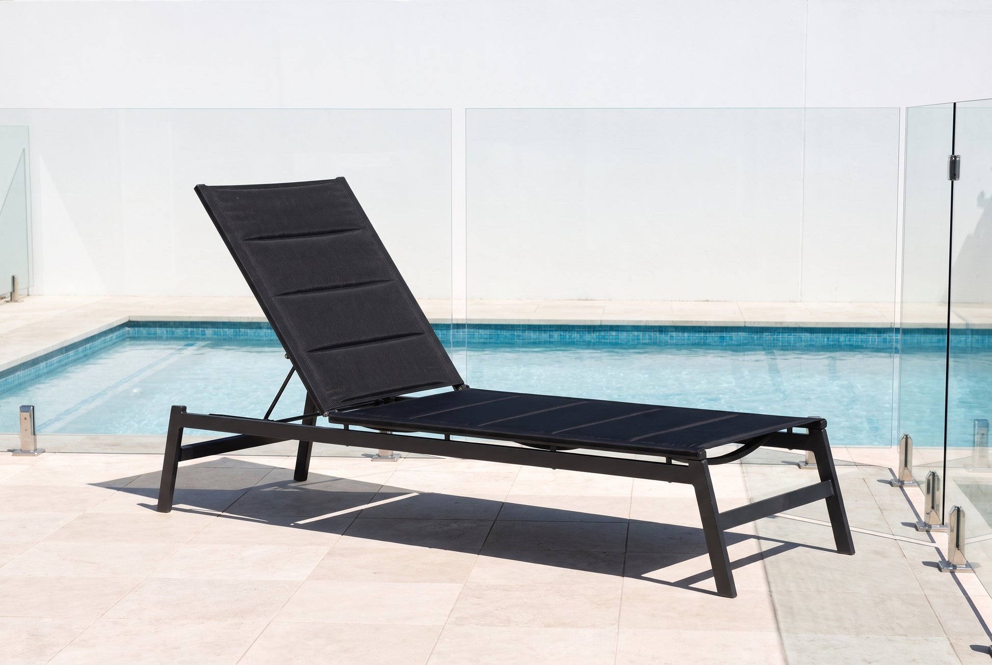 PRIMULA Padded Sunlounge in Gunmetal beside a pool