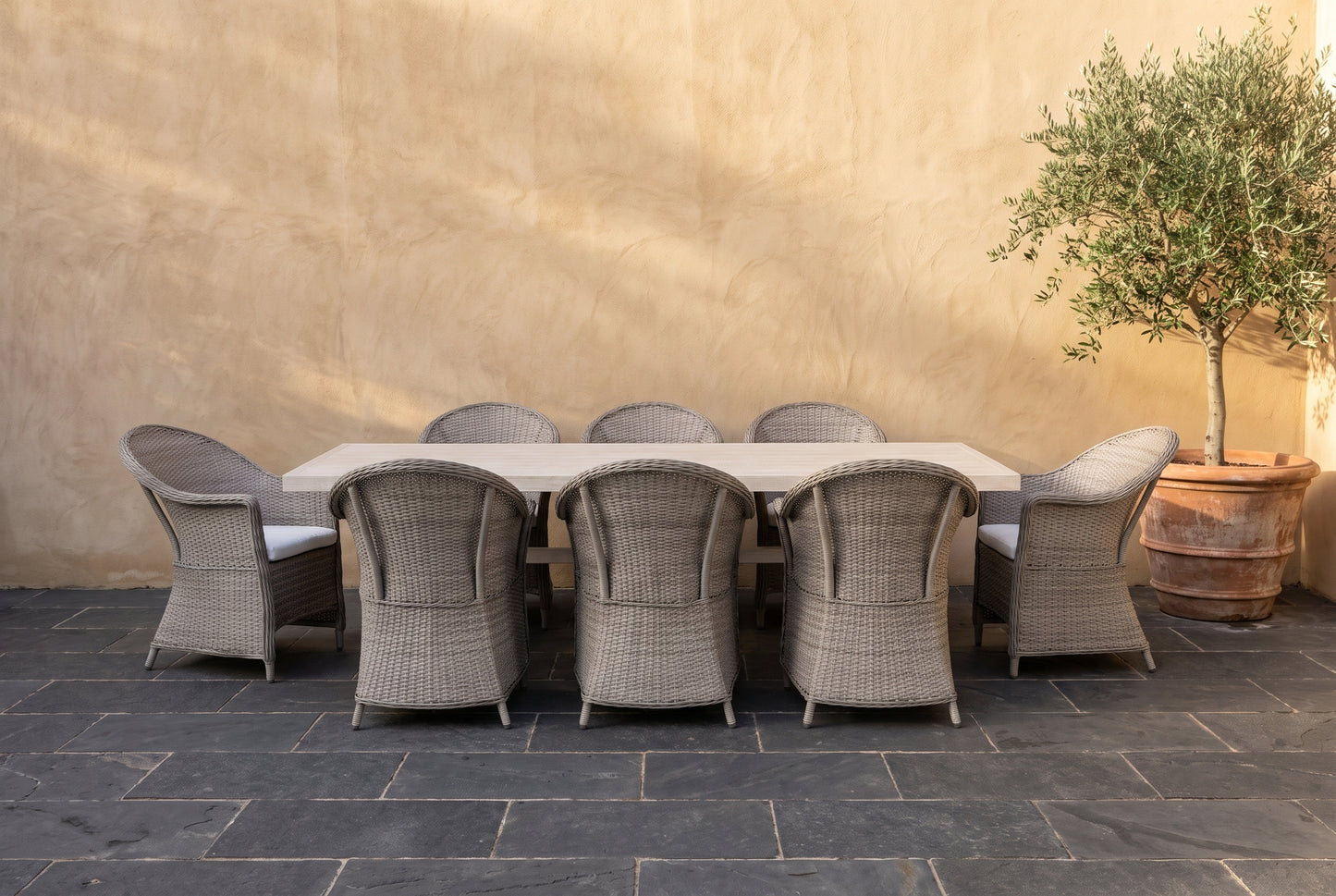 ZINNIA IX 8-Seater Outdoor Dining Setting on a dark charcoal stone paved terrace